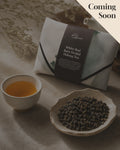 Gift tea set for the 'White Bud Orchid Oolong Tea' from Cha Cha Chan, featuring a packet of loose tea leaves, a postcard, and a reusable magic wrap.