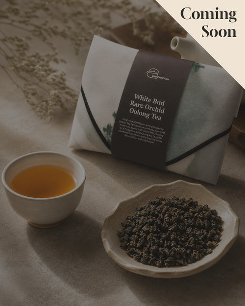 Gift tea set for the 'White Bud Orchid Oolong Tea' from Cha Cha Chan, featuring a packet of loose tea leaves, a postcard, and a reusable magic wrap.